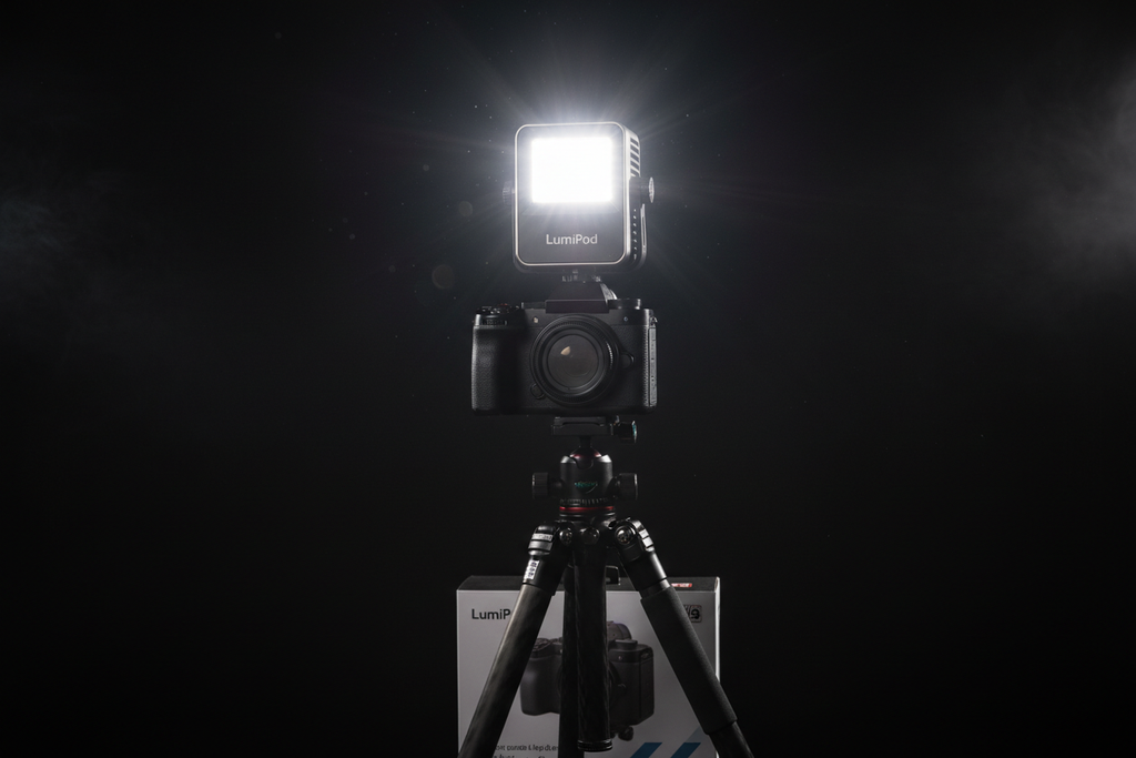 Compact portable LED video light panel mounted on camera hotshoe in dark studio